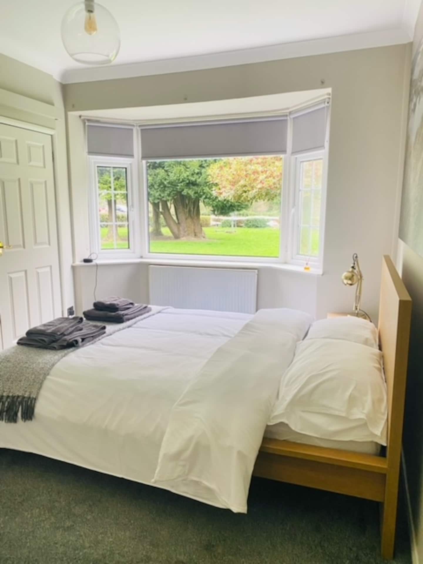 Second double bedroom with cosy decor and warm morning light