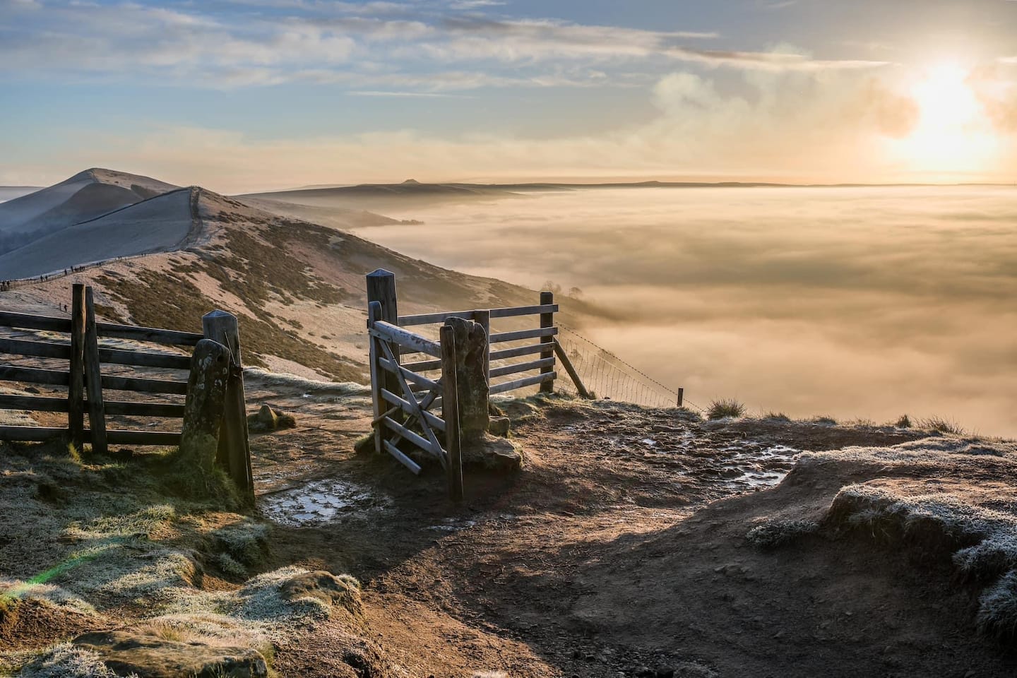 Hikers on a Peak District ridgeline with dramatic moorland views stretching to the horizon